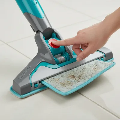 Close-up of a hand pressing the release button on the Shark Genius Pocket Steam Mop to detach a dirty pad.