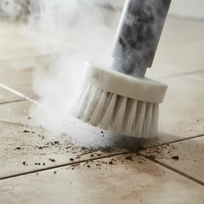 Close-up of a steam cleaner attachment cleaning dirty grout lines on a tile floor, demonstrating precise and effective grime removal.